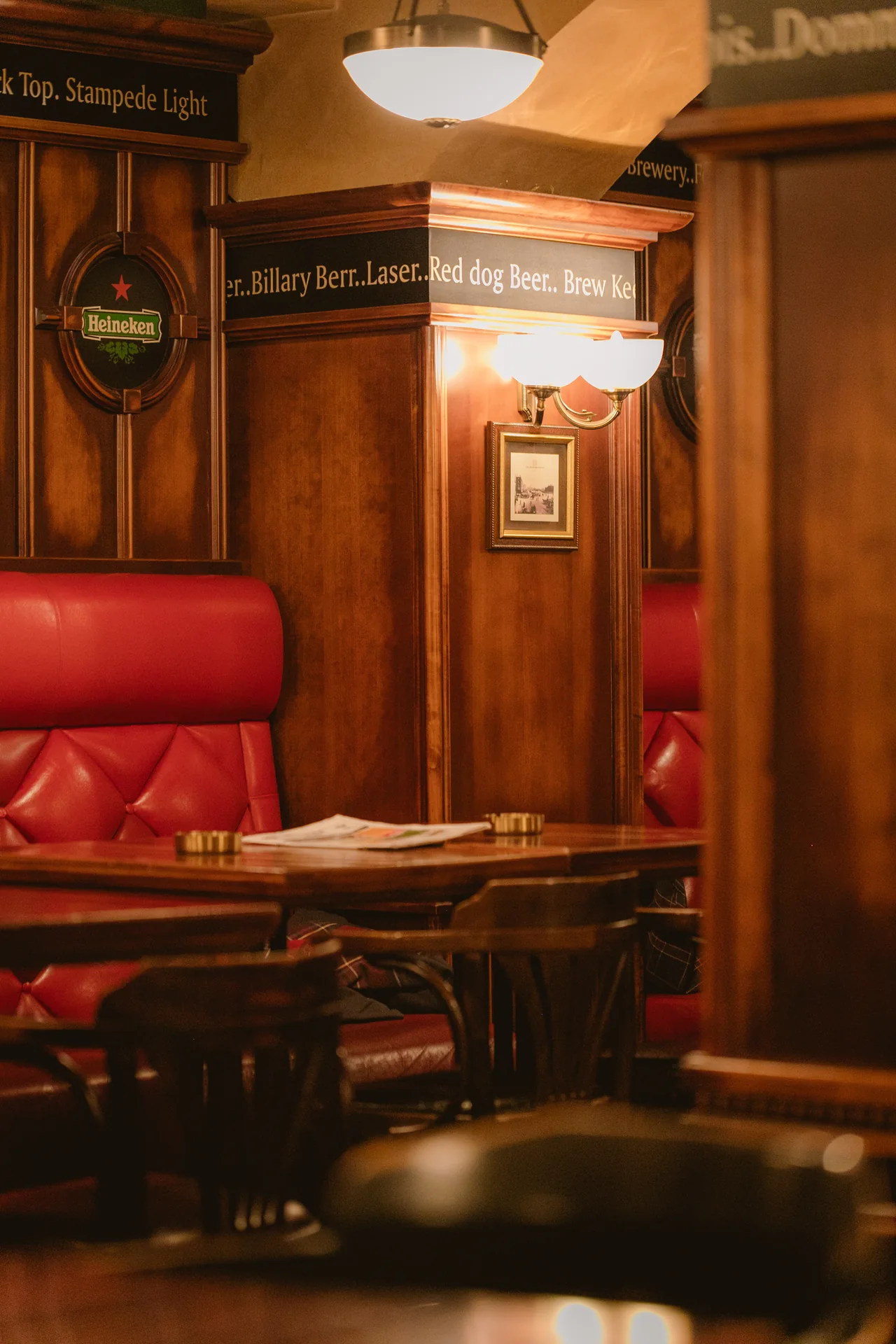 A warmly lit corner with red booths